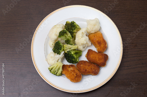 Dinner on a white plate that is on a dark background
