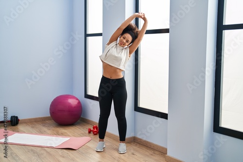 Young african american woman smiling confident stretching at sport center photo