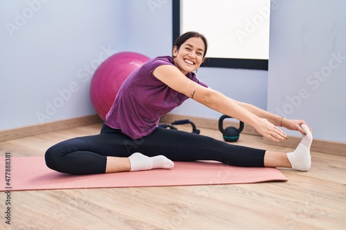Young woman smiling confident stretching at sport center