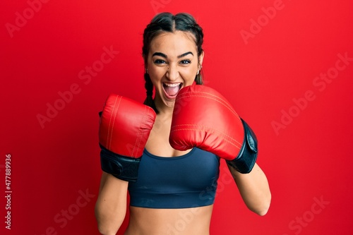 Young brunette girl using boxing gloves celebrating crazy and amazed for success with open eyes screaming excited. © Krakenimages.com
