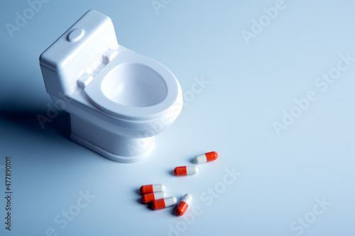 Papier peint toilet bowl miniature and pills on the table