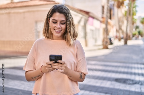 Young hispanic woman smiling confident using smartphone at street