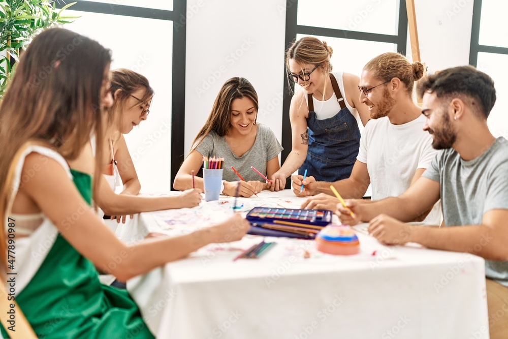 Obraz premium Group of young paint students smiling happy and drawing sitting on the table at art studio.