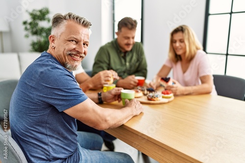 Group of middle age friends having breakfast sitting on the table at home.