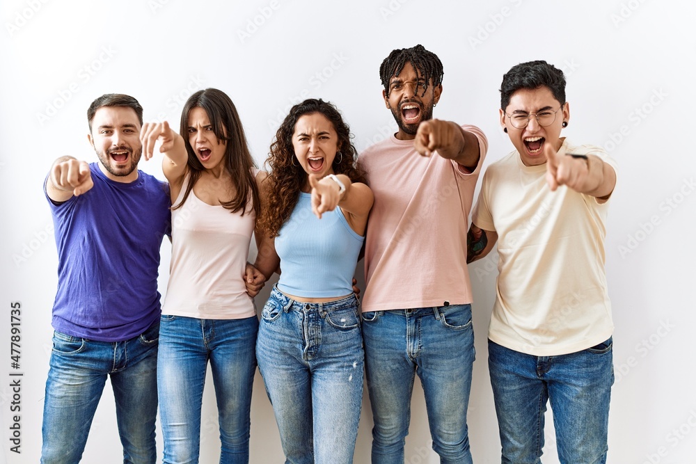 Group of young people standing together over isolated background pointing displeased and frustrated to the camera, angry and furious with you Group of young people standing together over isolated background pointing displeased and frustrated to the camera, angry and furious with you