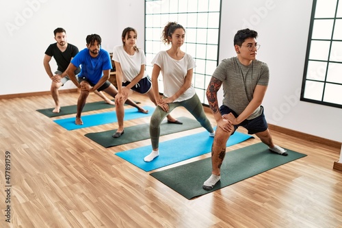 Group of young sporty people concentrate training yoga at sport center.