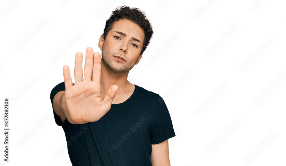 Young handsome man wearing casual black t shirt doing stop sing with palm of the hand. warning expression with negative and serious gesture on the face. Young handsome man wearing casual black t shirt doing stop sing with palm of the hand. warning expression with negative and serious gesture on the face.