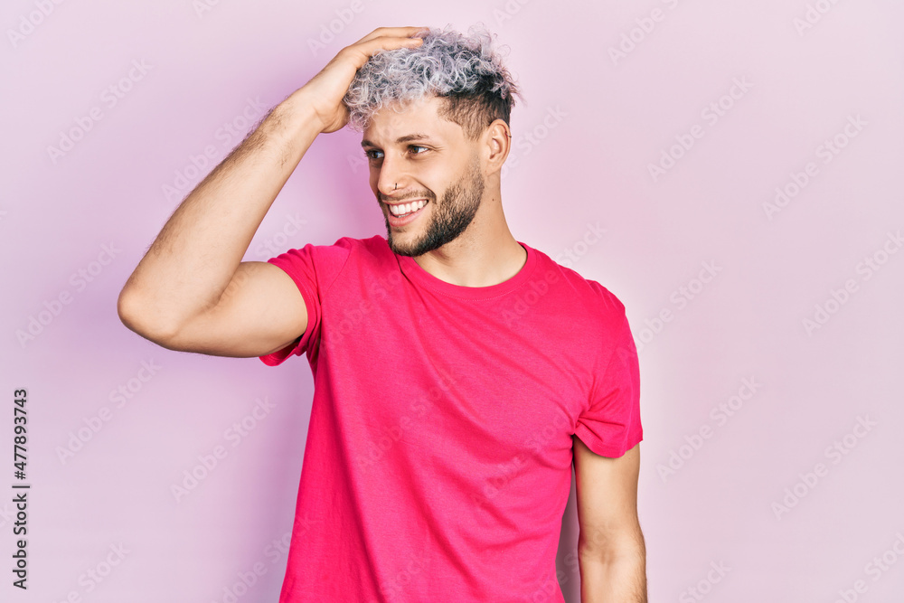 Young hispanic man with modern dyed hair wearing casual pink t shirt  smiling confident touching hair with hand up gesture, posing attractive and  fashionable Stock Photo | Adobe Stock