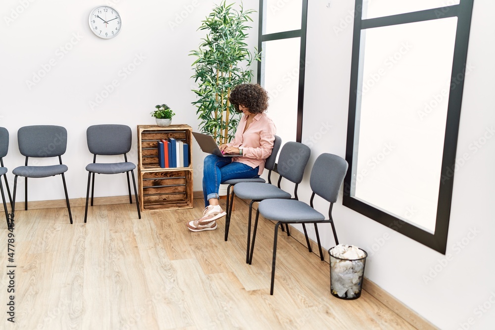 Young middle east woman using laptop sitting on chair at waiting room Young middle east woman using laptop sitting on chair at waiting room
