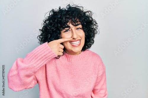 Young middle east woman wearing casual clothes pointing with hand finger to face and nose, smiling cheerful. beauty concept