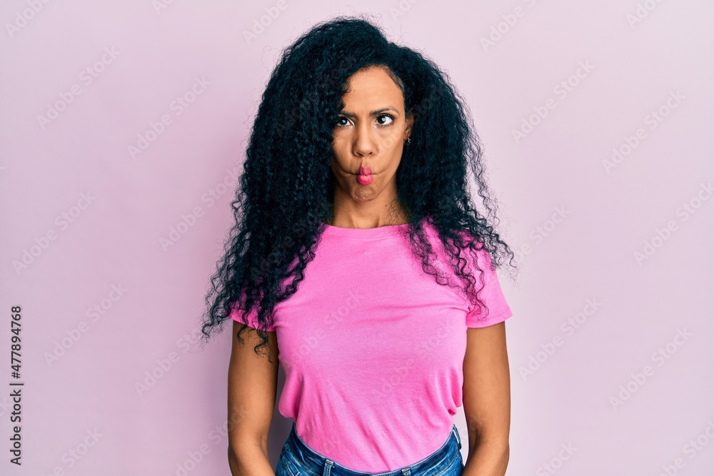Middle age african american woman wearing casual clothes making fish face with lips, crazy and comical gesture. funny expression. Middle age african american woman wearing casual clothes making fish face with lips, crazy and comical gesture. funny expression.