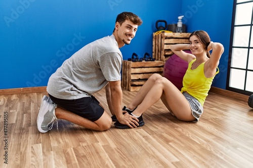 Man and woman couple training abs exercise at sport center