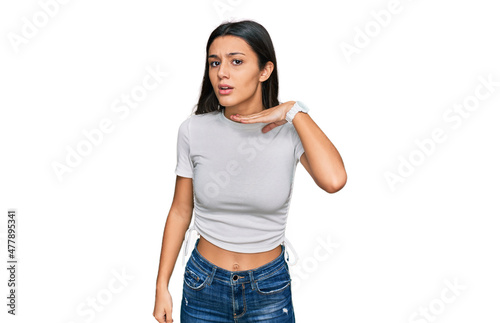 Young hispanic girl wearing casual white t shirt cutting throat with hand as knife  threaten aggression with furious violence