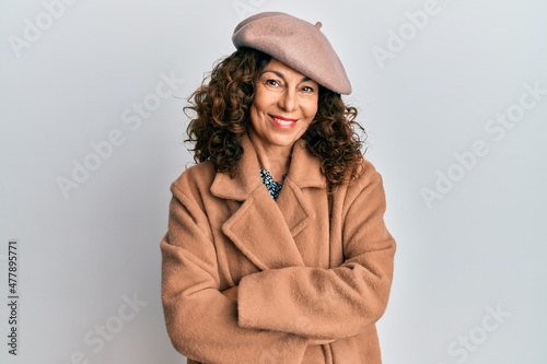 Middle age hispanic woman wearing french look with beret happy face smiling with crossed arms looking at the camera. positive person.