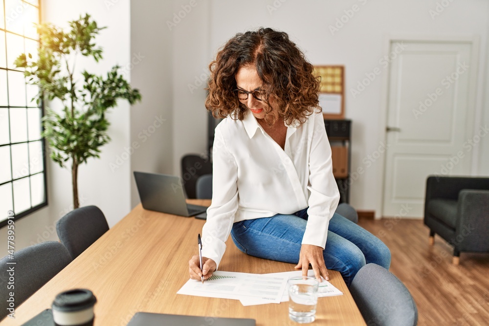 Middle age hispanic woman smiling confident working at office Middle age hispanic woman smiling confident working at office