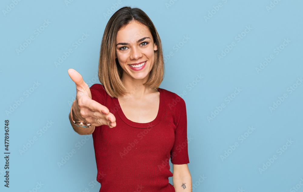 Young blonde girl wearing casual clothes smiling friendly offering handshake as greeting and welcoming. successful business. Young blonde girl wearing casual clothes smiling friendly offering handshake as greeting and welcoming. successful business.