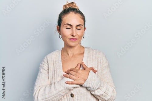 Young caucasian woman wearing casual clothes smiling with hands on chest, eyes closed with grateful gesture on face. health concept.