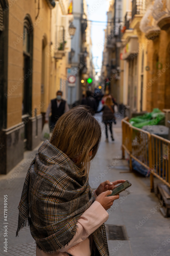 Woman using mobile phone on a street in the city center