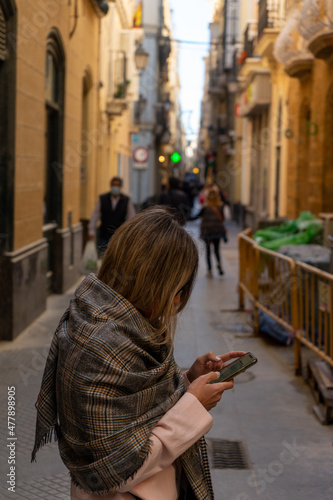 Woman using mobile phone on a street in the city center © TxemaPhoto