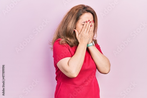 Middle age caucasian woman wearing casual clothes with sad expression covering face with hands while crying. depression concept.
