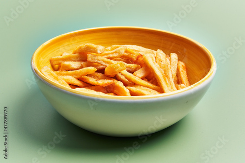  Bowl of french fried potatoes over green background