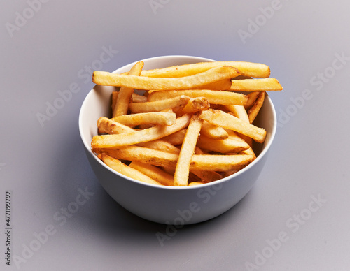  Bowl of french fried potatoes over grey background