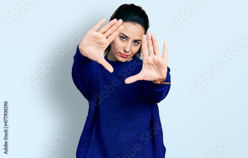 Young hispanic woman wearing casual clothes doing frame using hands palms and fingers, camera perspective