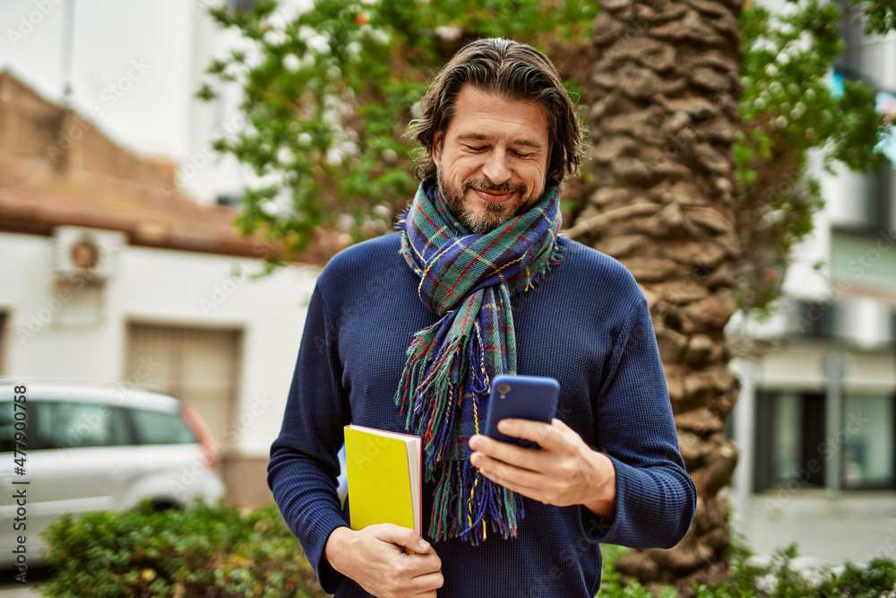 Fototapeta premium Middle age handsome man using smartphone outdoors at the park