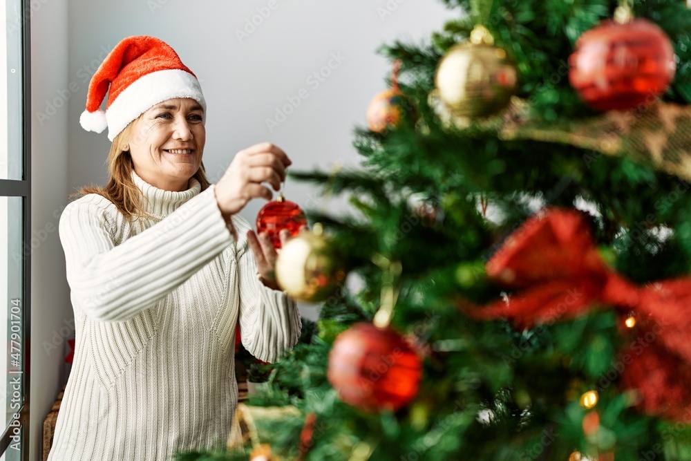Middle age caucasian woman smiling confident decorating christmas tree at home Middle age caucasian woman smiling confident decorating christmas tree at home