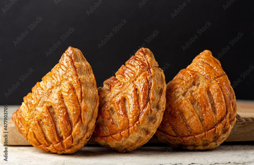 Apple turnovers, or chaussons aux pommes, a classic French puff pastry that  is filled with apple sauce. Black background. Stock Photo | Adobe Stock