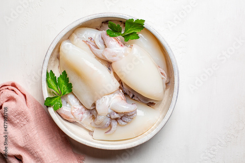 Cuttlefish sepia marine molluscs in a white plate, ready to be cooked. photo