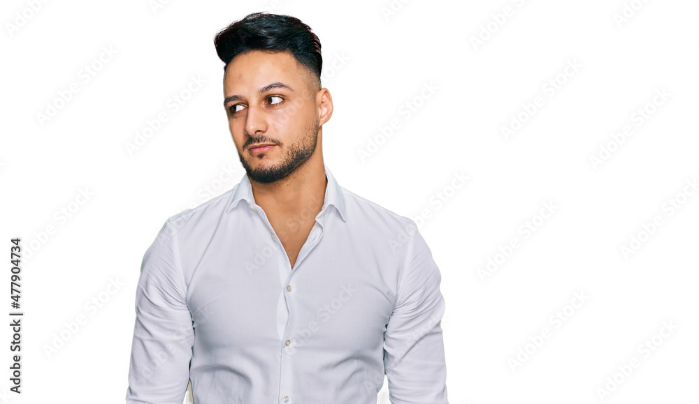 Young arab man wearing casual clothes smiling looking to the side and staring away thinking. Young arab man wearing casual clothes smiling looking to the side and staring away thinking.