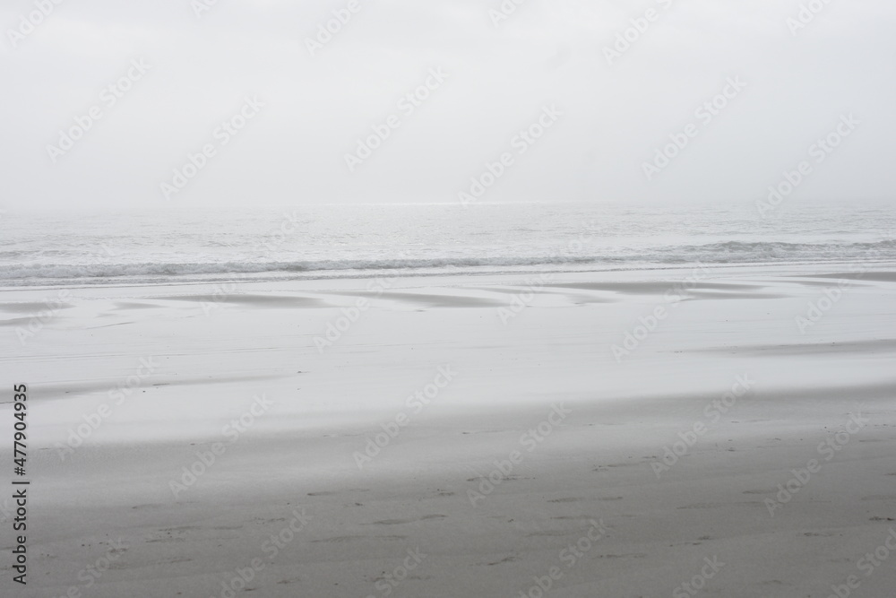 Calm serene ocean beach on a gray hazy winter afternoon