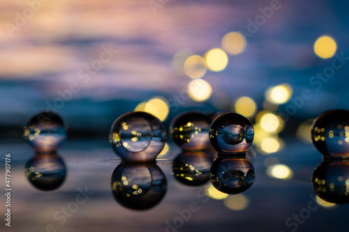 Glass spheres reflecting sunset on beach