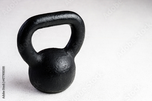 Kettlebell winter fitness, black kettlebell on a white background with silver sparkles 