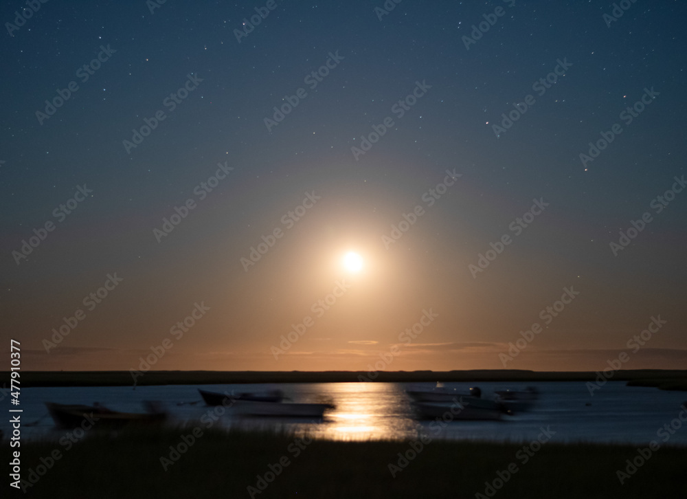 Boats Blurred by Motion of Ocean as the Moon Rises at Night
