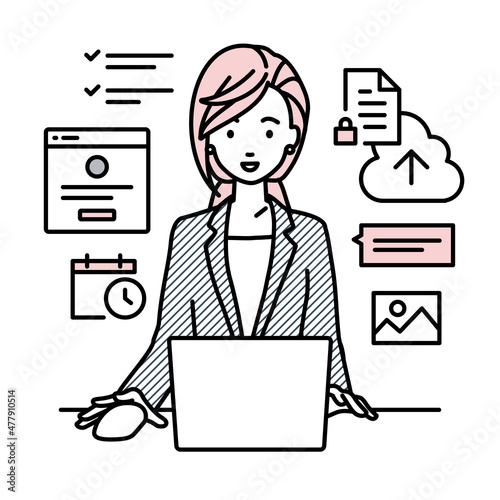 デスクで座ってPCでプロジェクトやタスクの管理の仕事をしているスーツの女性