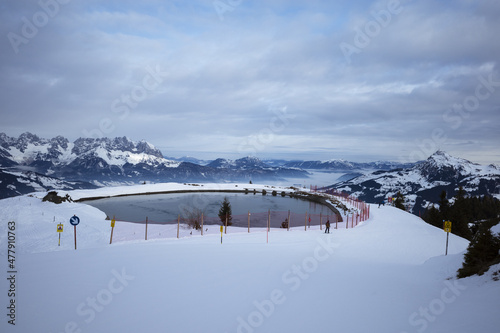 Obraz na płótnie Kirchberg, Austria - December 26, 2021: Ski resort Kitzski in the Alps. Mountain snowy peaks, alpine village. Water pond w salonie