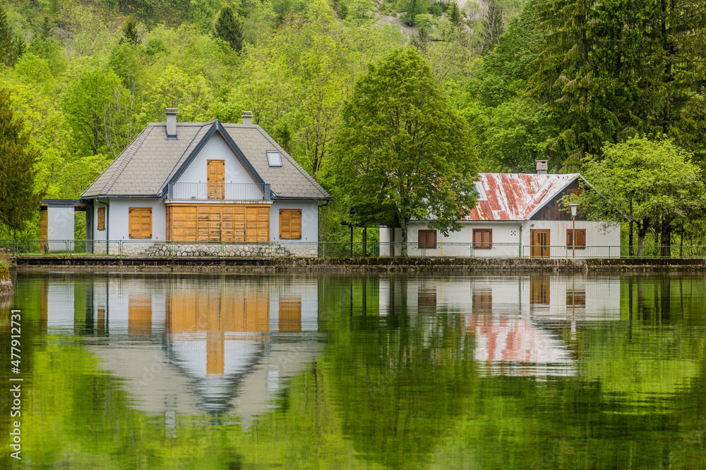 Houses reflecting in Pluzensko jezero lake near Bovec village, Slovenia