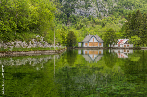 Houses reflecting in Pluzensko jezero lake near Bovec village, Slovenia