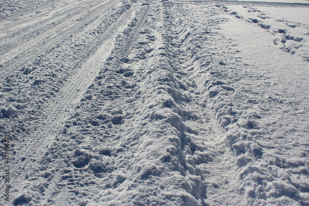 Automobile tire tread marks on a snowy winter road