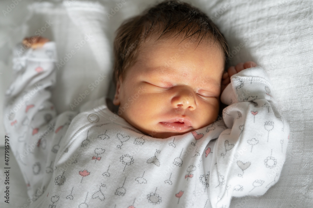 Close up on newborn caucasian baby sleeping in bed on first day of her life - cute little infant boy or girl sleep peacefully Close up on newborn caucasian baby sleeping in bed on first day of her life - cute little infant boy or girl sleep peacefully