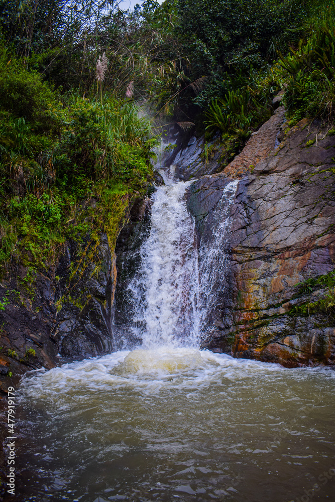 Small waterfall descends between the rocks of a mountain. Small waterfall descends between the rocks of a mountain.