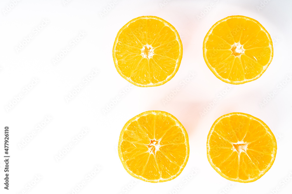 Four tangerine halves on the right and copy space on the left with white background