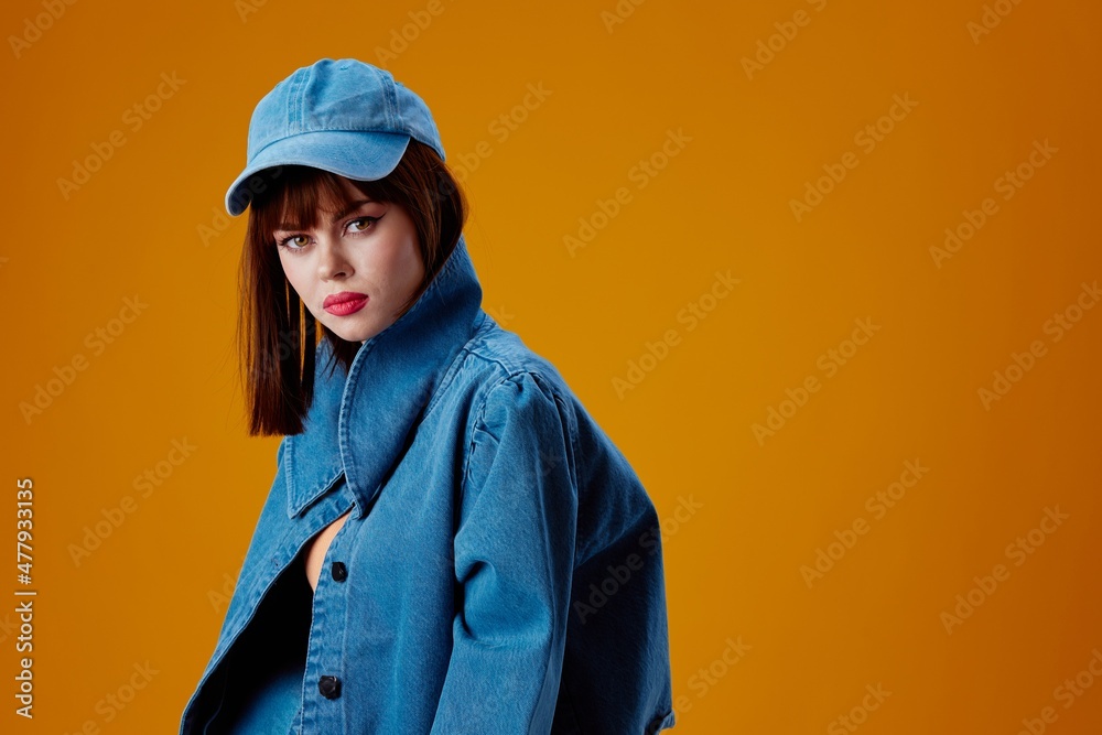 pretty woman denim clothing fashion posing cap yellow background unaltered