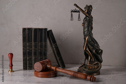 Lady Justice, Judge's gavel, books, parchment scroll with seal and stamp on an old wooden table