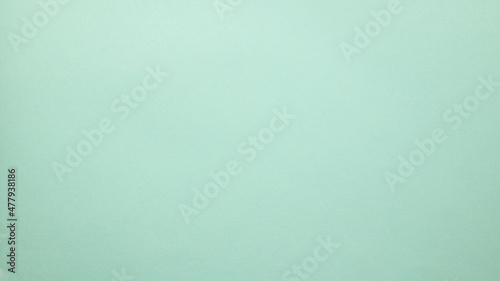 Smooth flat vintage paper bag pale texture in light blue color on table background.