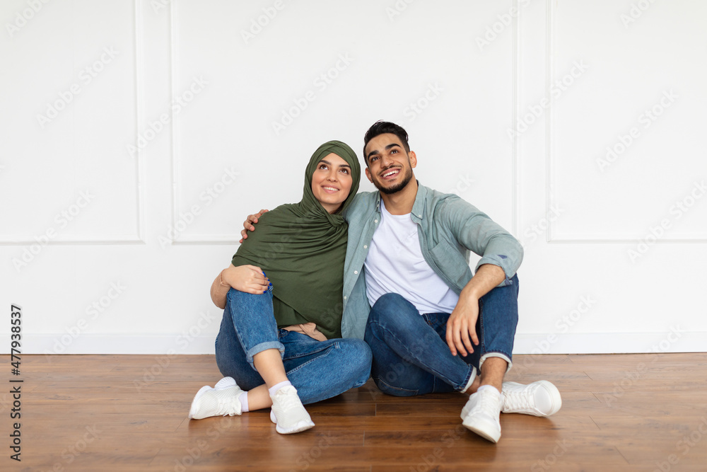 Happy muslim man and woman looking up at home Happy muslim man and woman looking up at home