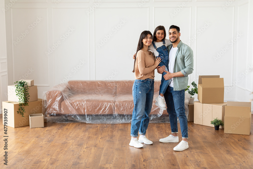 Happy family looking at camera, posing on moving day Happy family looking at camera, posing on moving day
