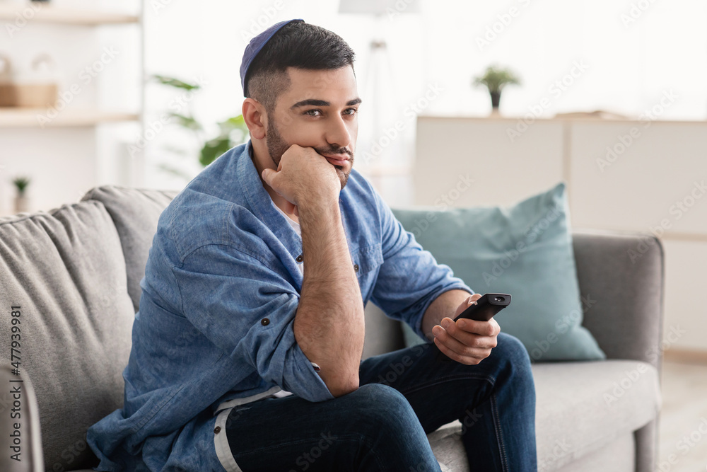 Bored jewishman watching television sitting on couch Bored jewishman watching television sitting on couch
